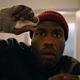 Yahya Abdul-Mateen II in the 2021 Candyman raises a bandaged hand to protect himself.